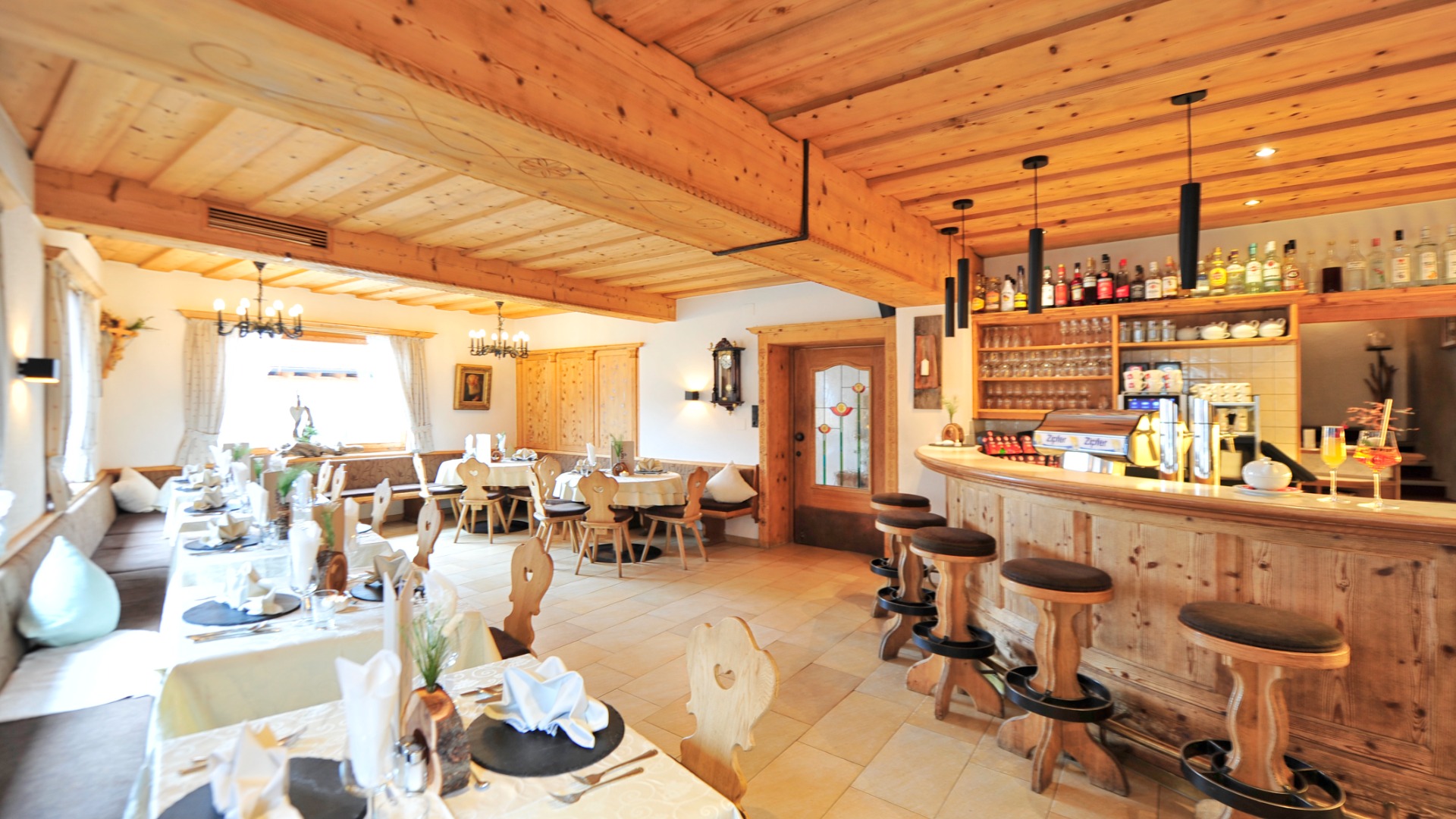 Restaurantbereich mit Bar, Sitzplätzen und gemütlicher Atmosphäre im Hotel Traube in Fließ.
